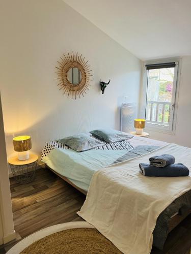 une chambre avec deux lits et un miroir au mur dans l'établissement Chaleureux Et Lumineux Duplex T2, à La Rochelle