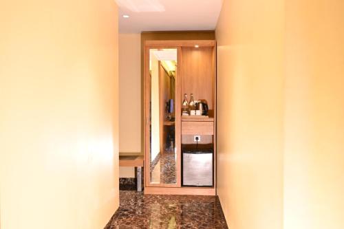 a hallway leading to a bathroom with a mirror at The Fern Residency Kolkata in Kolkata