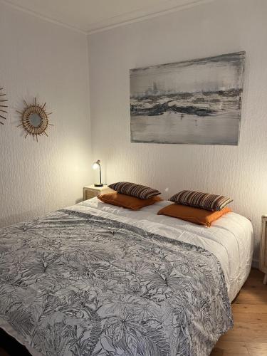 une chambre avec un lit avec deux oreillers dessus dans l'établissement Pontaillac Royan T2 Belle Terrasse, à Vaux-sur-Mer