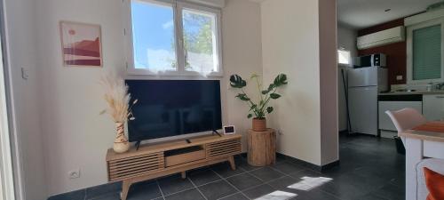 un salon avec une télévision à écran plat sur un meuble dans l'établissement LE SILENCE DES BOIS Séjour romantique et bien-être, à Étoile-sur-Rhône