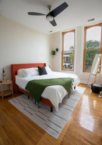 a white bedroom with a bed with a green blanket at The Getaway in DT Northfield! in Northfield