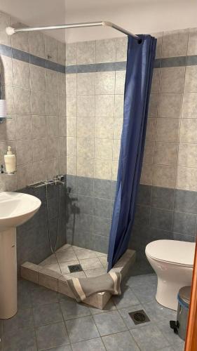 a bathroom with a shower with a sink and a toilet at romanza rooms in Poulithra