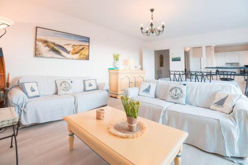 - un salon avec deux canapés blancs et une table dans l'établissement Voile d'or - Appartement 3 chambres spacieux, à Le Touquet-Paris-Plage