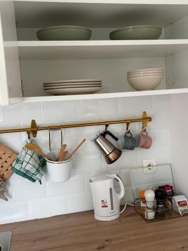 a kitchen shelf with plates and utensils on it at Studio 360 in Portorož
