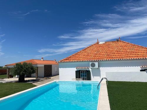 a swimming pool in front of a house at Adega Monte Maneta in Setubal