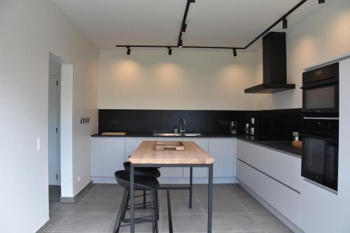 a kitchen with a wooden table and a counter at de Graspieper in Oostduinkerke