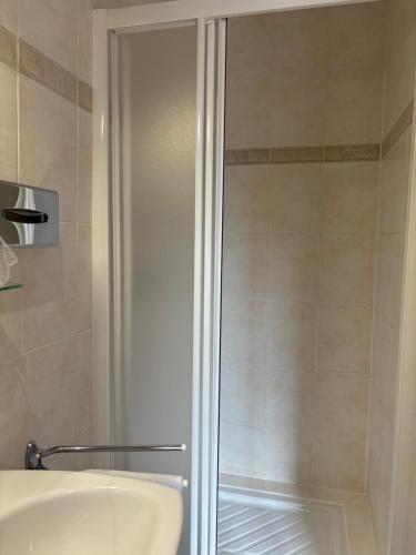 a shower with a glass door next to a sink at Chez Anabel et Stéphane in Battenheim