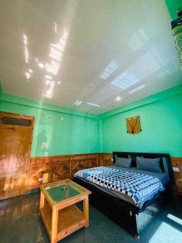 a bedroom with a bed and a table in it at Trippy Homestay in Kasol