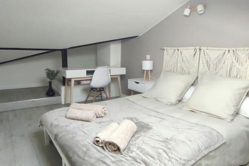 une chambre avec un grand lit blanc avec des serviettes dessus dans l'établissement Le cocon de Rose, à Toulouse