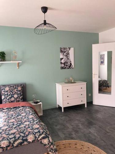 - une chambre avec un lit, une commode et une lampe dans l'établissement chez karine 6, à Arpajon