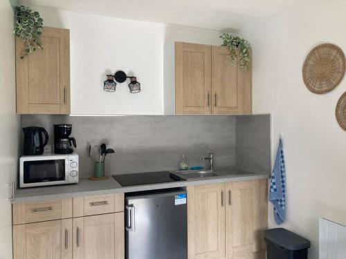 une cuisine avec des armoires en bois et un réfrigérateur en acier inoxydable dans l'établissement chez karine 6, à Arpajon