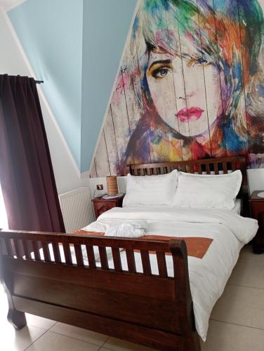 a bedroom with a painting of a woman on the wall at Pensiunea Lina in Lepşa