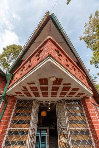 a red brick house with a large open doorway at Unique 2BHK in Bhowali Red Brick Quarter in Bhowāli