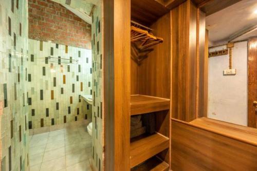 a walk in closet with wooden shelves and a brick wall at Unique 2BHK in Bhowali Red Brick Quarter in Bhowāli