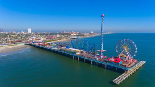 an aerial view of a pier with a ferris wheel at Holiday Inn Resort Galveston - On The Beach by IHG in Galveston