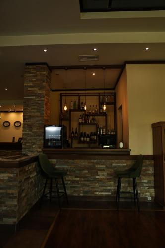a bar in a restaurant with two green chairs at Dilijan Park Resort & Villas in Dilijan