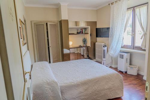 a bedroom with a white bed and a window at Domus Fontis Pescaia in Spoleto