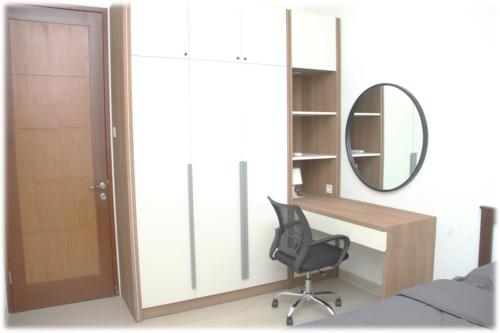 a bedroom with a desk and a chair and a mirror at Calm, cozy and relaxing house in Bandung