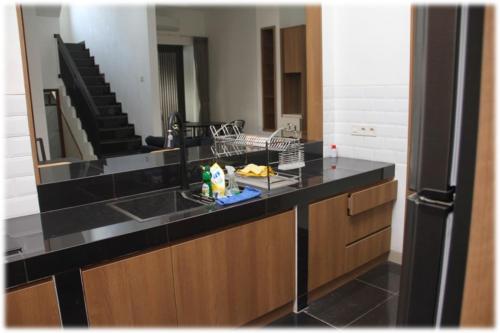 a kitchen with a counter with a sink and a mirror at Calm, cozy and relaxing house in Bandung