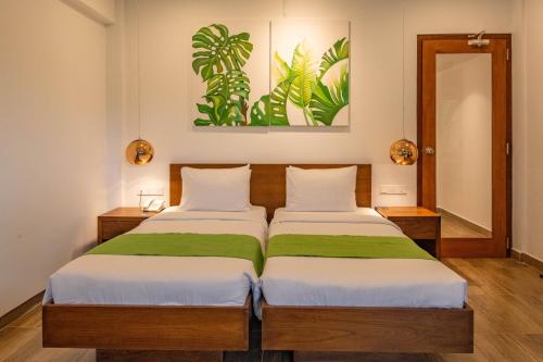 a bedroom with two beds and a mirror at Agnus Unawatuna in Unawatuna