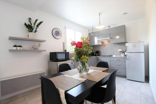 une cuisine avec une table avec un vase de fleurs dessus dans l'établissement Haitzburua, à Hasparren