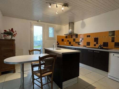 - une cuisine avec un évier, une table et des chaises dans l'établissement Bixta-eder, à Saint-Palais