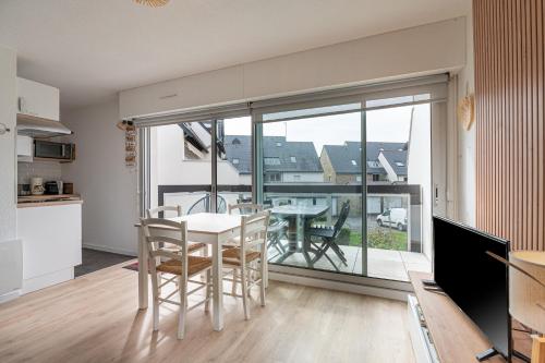 une cuisine et une salle à manger avec une table et des chaises dans l'établissement Appartement Ty Soleil - Proche mer, à Carnac