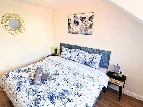 a bedroom with a bed with a blue and white comforter at Luxury Spacious Apartment- Sleeps 4 Loughborough in Loughborough