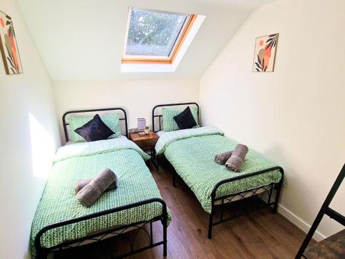 two twin beds in a room with a window at Luxury Spacious Apartment- Sleeps 4 Loughborough in Loughborough