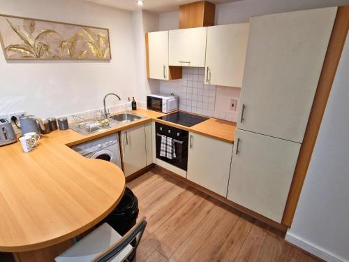 a kitchen with a wooden table and a wooden floor at Luxury Spacious Apartment- Sleeps 4 Loughborough in Loughborough