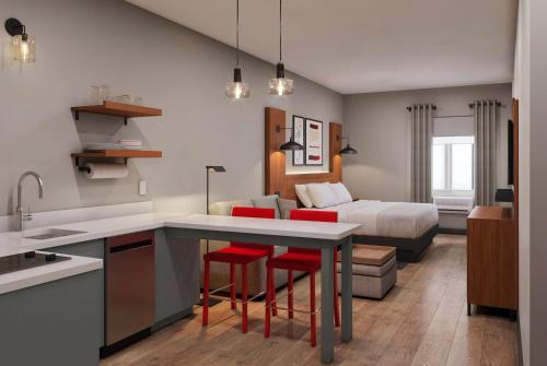 eine Küche und ein Wohnzimmer mit einem Bett in einem Zimmer in der Unterkunft Hawthorn Extended Stay by Wyndham Kingman in Kingman