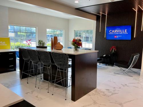 a lobby with a bar with chairs and a tv at Days Inn by Wyndham Arlington in Arlington