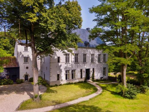 an exterior view of a white mansion with trees at Waterloo Le Manoir de Lasne in Lasne