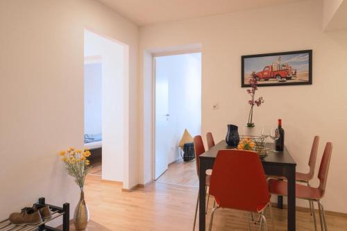 a dining room with a table and red chairs at HITrental Chapel Bridge Apartments in Luzern