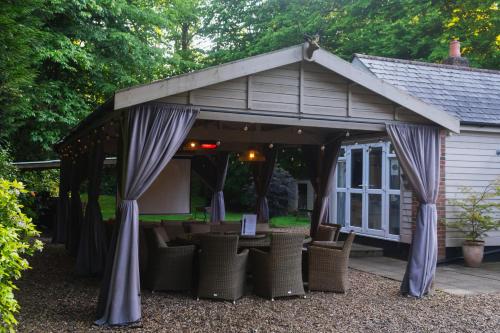 a gazebo with tables and chairs in a yard at The Bungalow by TAS in Knebworth