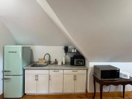 a kitchen with a sink and a refrigerator at The Lakeview Loft in Port Colborne