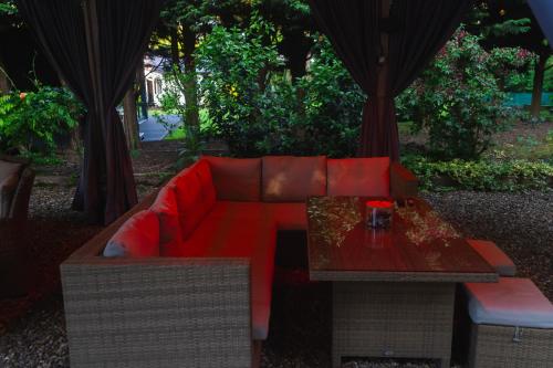 a red couch and a table with a coffee table at The Bungalow by TAS in Knebworth