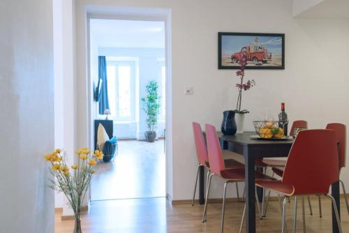 a dining room with a table and red chairs at HITrental Chapel Bridge Apartments in Luzern