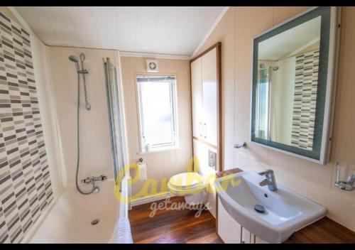 a bathroom with a sink and a shower and a mirror at MP768 - Camber Sands Holiday Park - Huge Lodge - Small dog friendly - sleeps 8 in Camber