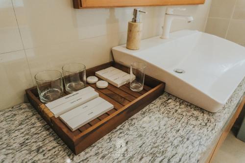 a bathroom with a wooden tray with glasses and a sink at The paddies villa #2 in Tampaksiring