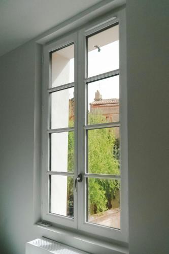 an open window with a view of a building at ô Quai St Pierre in Toulouse