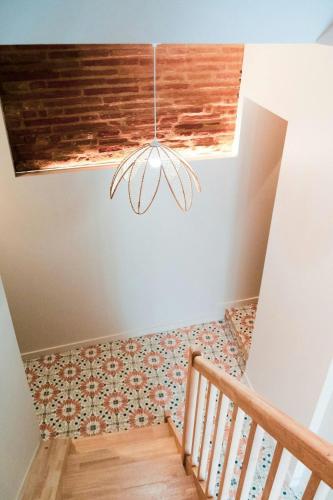 a room with a staircase with a chandelier at ô Quai St Pierre in Toulouse