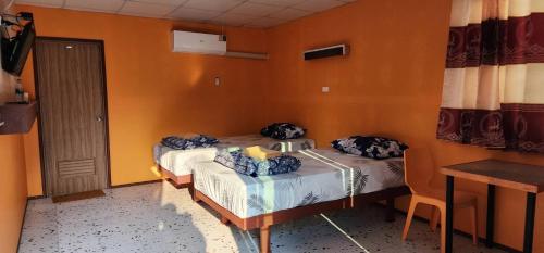 two beds in a room with orange walls at Bondoilampang in Ban Thung