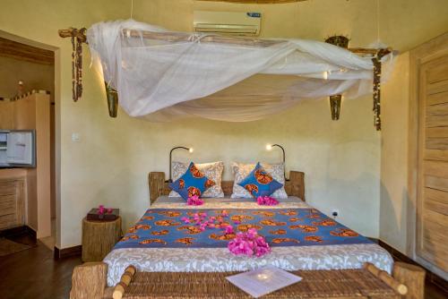 a bedroom with a large bed with flowers on it at Keur Palmier Saly in Saly Portudal