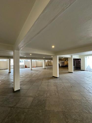 an empty room with white columns and a large ceiling at Hotel Mysore Radiance in Mysore