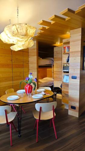 a dining room with tables and chairs and a bed at Hostdomus - Copenaghen Suite in Sestriere