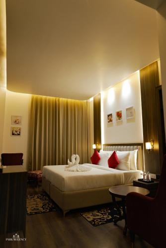a hotel room with a large bed with red pillows at Park Regency Kapurthala in Kapūrthala