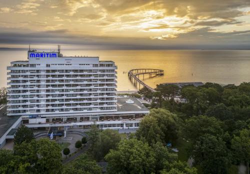 a large white hotel with a pier in the water at Maritim Seehotel Timmendorfer Strand in Timmendorfer Strand