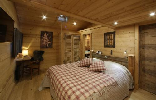 a bedroom with a bed and a desk in a cabin at Chalet Pesse in Manigod