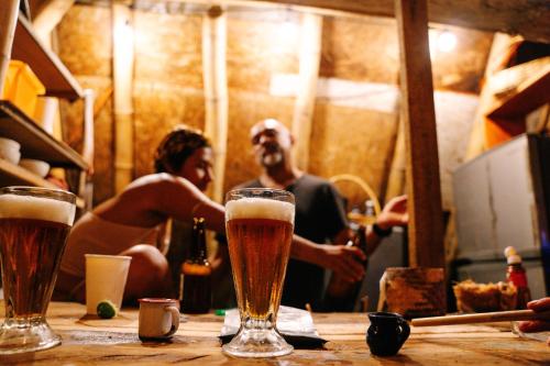a group of people sitting at a table with glasses of beer at Balamjuyuc Cabañas y Ecohostel in Santa María Tonameca